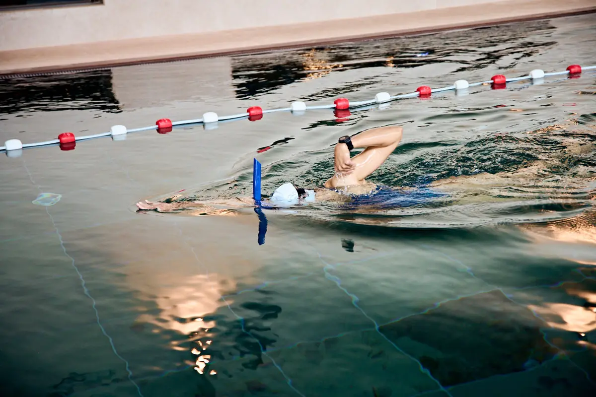 A swimmer with a centre snorkel practises the arm recovery, hand passing the shoulder